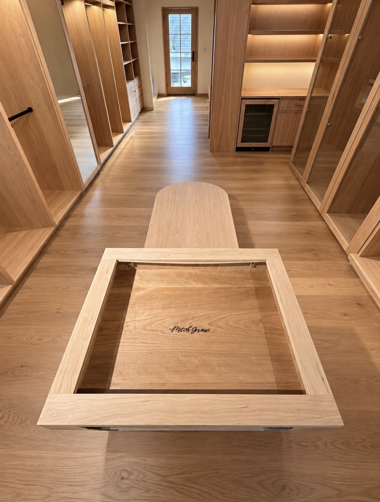 Wood dressing room island with inset tray and fitted wardrobe storage