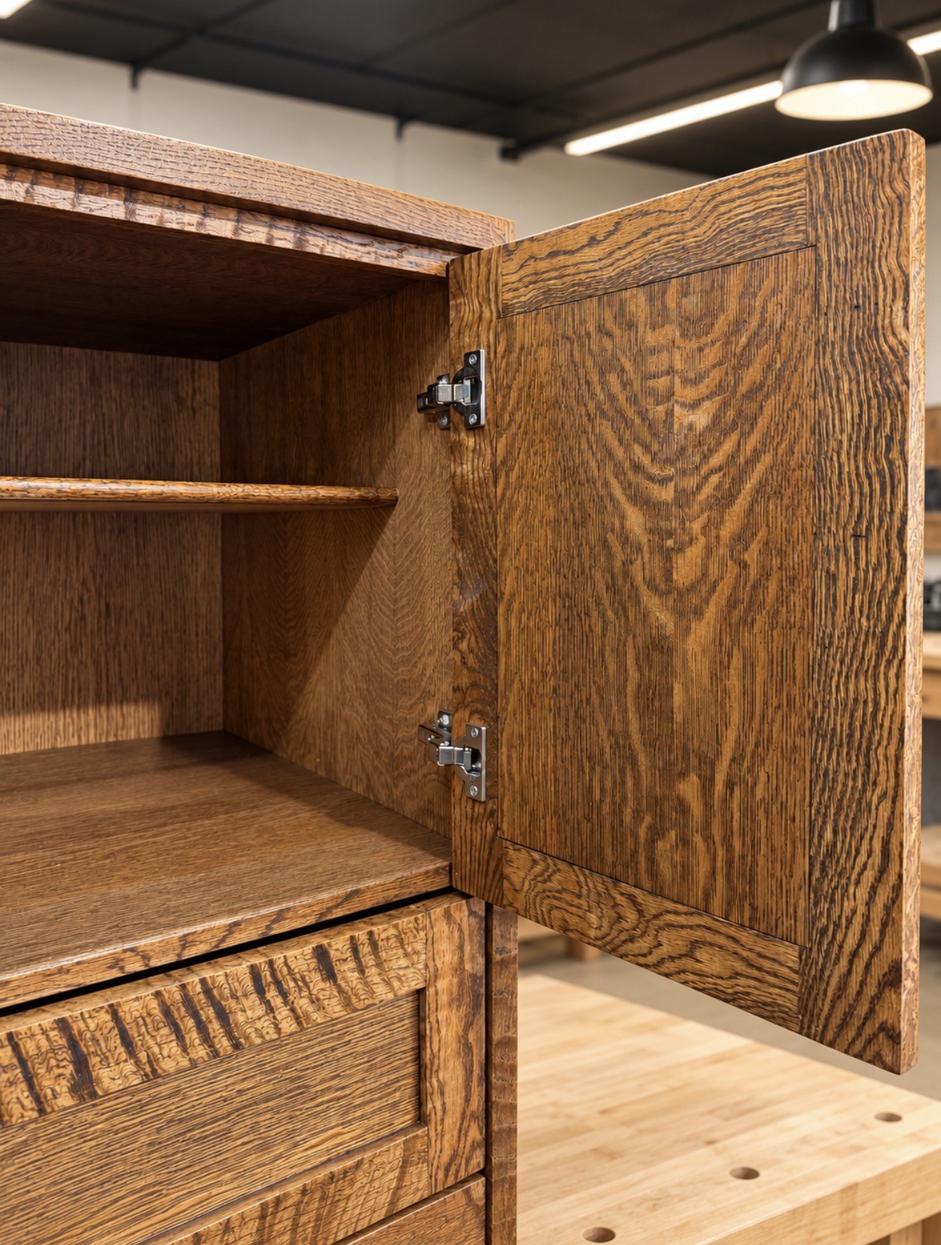 Close view of oak cabinet door, hinges, shelves, and drawer fronts