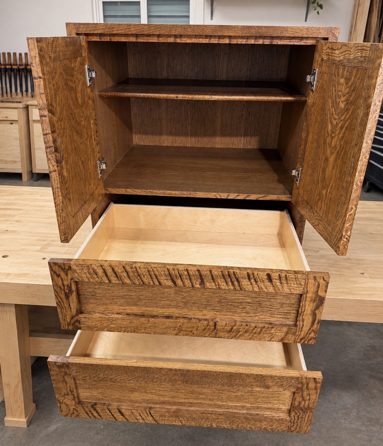 Open oak cabinet showing shelves and extended drawers